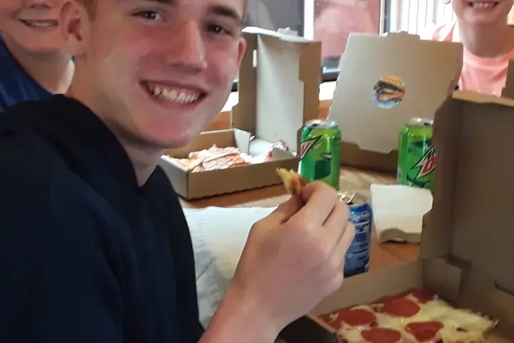 kids at a table eating pizza